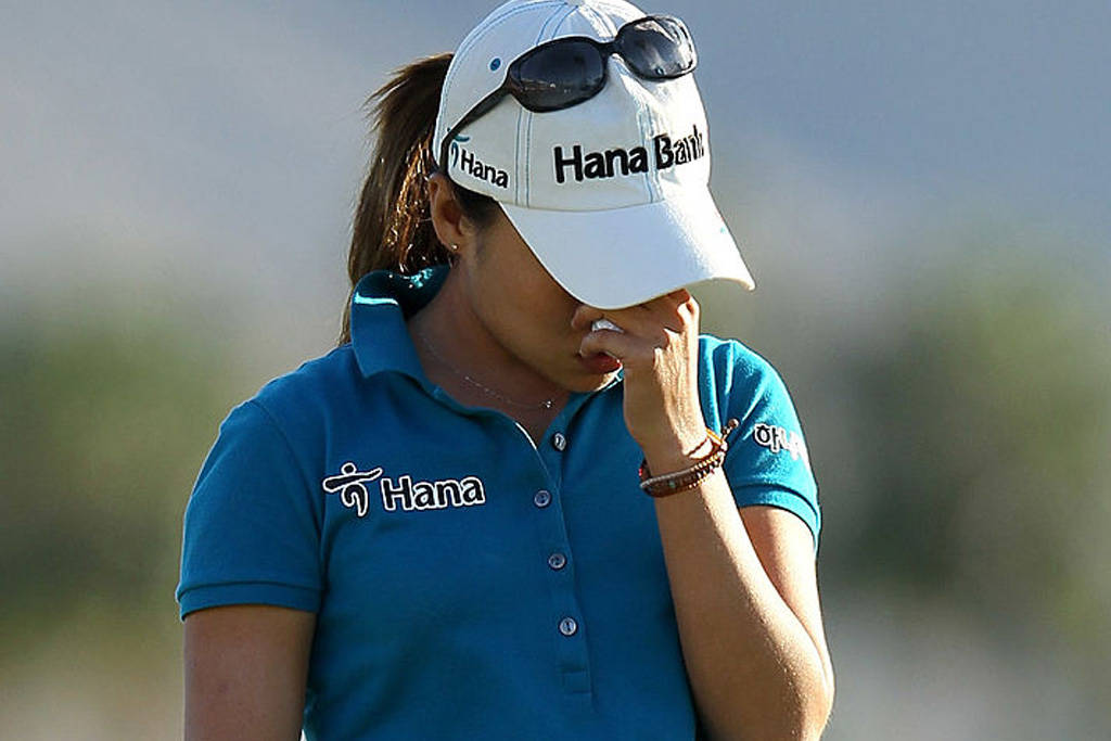 I K Kim holds her head in her hands after missing a one-foot putt for victory at the 2012 Kraft Nabisco Championship.